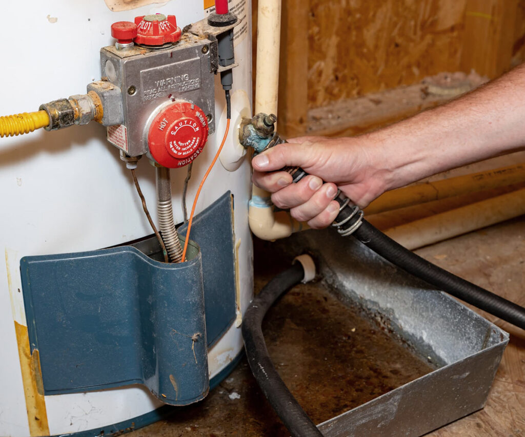 All County Plumbing & Leak plumber draining an old water heater tank